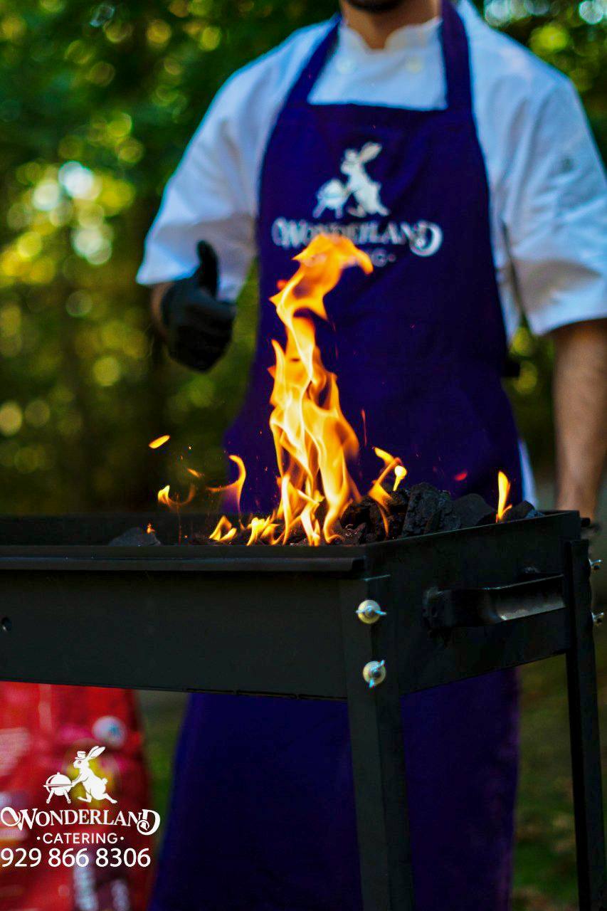 Charcoal flames in front of a catering chef